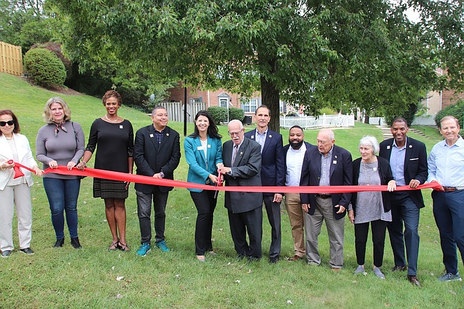 Officials from all sides cut the ribbon on Good Shepherd’s 100th housing unit. 